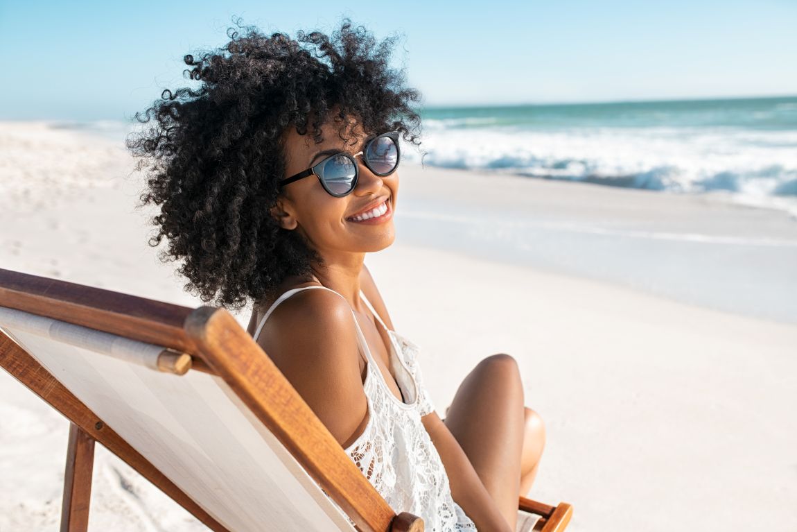 woman in chair smiling on beach